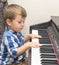 Little happy boy plays piano
