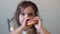 Little happy cute girl is eating donut. child is having fun with donut. Tasty food for kids. Funny time at home with