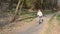 Little happy girl child rides a bicycle in the autumn forest