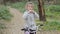 Little happy girl child rides a bicycle in the autumn forest