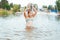 Little happy girl plays with water and splashes of water in the sea