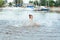 Little happy girl plays with water and splashes of water in the sea