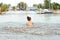 Little happy girl plays with water and splashes of water in the sea