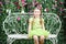 Little happy girl sits on white retro bench