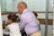 Little happy toddler girls and grandfather in bathroom washing hands.