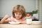 Little healthy hungry baby boy eating soup from plate with spoon.