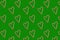 Little hearts from christmas candies on a green background. Seamless wrapping paper concept, wallpaper, pattern for fabric.