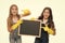 A little help for keeping things tidy. Adorable tidy schoolgirls in rubber gloves pointing at tidy blackboard. Primary