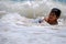 Little Hispanic boy playing in the ocean waves