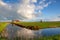 Little house, river, and white puffy clouds