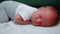 Little human life. Camera zooming on adorable caucasian sleeping infant baby. Indoor shot of tired newborn sleeping on