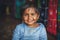 A little Indian girl looks at the camera and smiles at the photographer. Chocolate baby. Indian child in old clothes. Portrait of