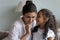 Little Indian girl share secret on loving attentive mothers ear