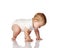 Little infant baby boy in white bodysuit crawls, tries to stand up, touching floor, going to start