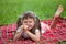 Little irritated girl preschooler lying on plaid