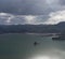 A little island with a few trees in the middle of a bay with mountains in the background in New Zealand