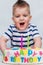 Little kid blows a candle on the cake on his birthday