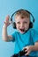 Little kid boy 2-3 years old wearing blue clothes hold in hand joystick for gameson blue background children studio portrait.