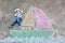 Little kid boy as pirate on ship or sailingboat picture painting with colorful chalks on asphalt.