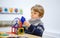 Little kid boy building geometric figures with plastic blocks