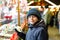 Little kid boy, cute child eating bananas covered with chocolate, marshmellows and colorful sprinkles near sweet stand