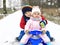 Little kid boy and cute toddler girl sitting together on sledge. Siblings, brother and baby sister enjoying sleigh ride