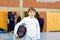 Little kid boy fencing on a fence competition. Child in white fencer uniform with mask and sabre. Active kid training