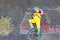 Little kid boy in fireman uniform having fun with fire truck picture drawing with colorful chalk on asphalt