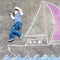 Little kid boy having fun with ship picture drawing with chalk