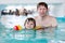 Little kid boy and his father swimming in an indoor pool