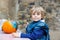 Little kid boy painting with colors on pumpkin