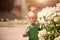 Little kid boy standing near flowerbed with blossoming petunia flowers