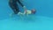 A little kid dives under the water for the ring