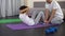 Little kid doing sit-ups and giving high five to his father, home exercising