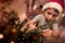 A little kid focused on ornamenting a Christmas tree at home. Together, New Year, family, celebration