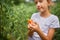 Little kid girl eating and enjoying of delicious harvest of organic red tomatoes