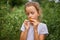 Little kid girl eating and enjoying of delicious harvest of organic red tomatoes