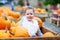 Little kid girl on pumpkin farm celebrating thanksgiving