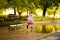 Little kid girl runs through a puddle. summer