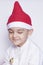 A little kid making a funny annoyed face. Annoyed Christmas Boy in Santa Hat. A really serious and handsome kid