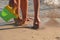 Little kid playing with bucket toys and walking on the beach at sunset