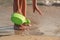 Little kid playing with bucket toys and walking on the beach at sunset