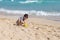 Little Kid playing with sand on the beach alone. Little boy near sea. Summer play