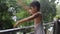 Little kid playing in summer rain in house balcony, Indian smart boy playing with rain drops during monsoon rainy season, kid