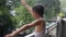 Little kid playing in summer rain in house balcony, Indian smart boy playing with rain drops during monsoon rainy season, kid