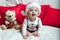 A little kid in a red cap eats a cookies and milk. Christmas photography of a baby in a red cap. New Year holidays and Christmas