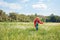 little kid in red superhero costume running in meadow