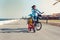 Little kid riding a balance bike with his mother on a bicycle