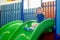 Little kid riding from childrens slides in game center and shows thumbs up. Happy little kid, children riding up, down on slide, i