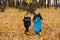 Little kid siblings collect trash using litter picker in a forest at autumn